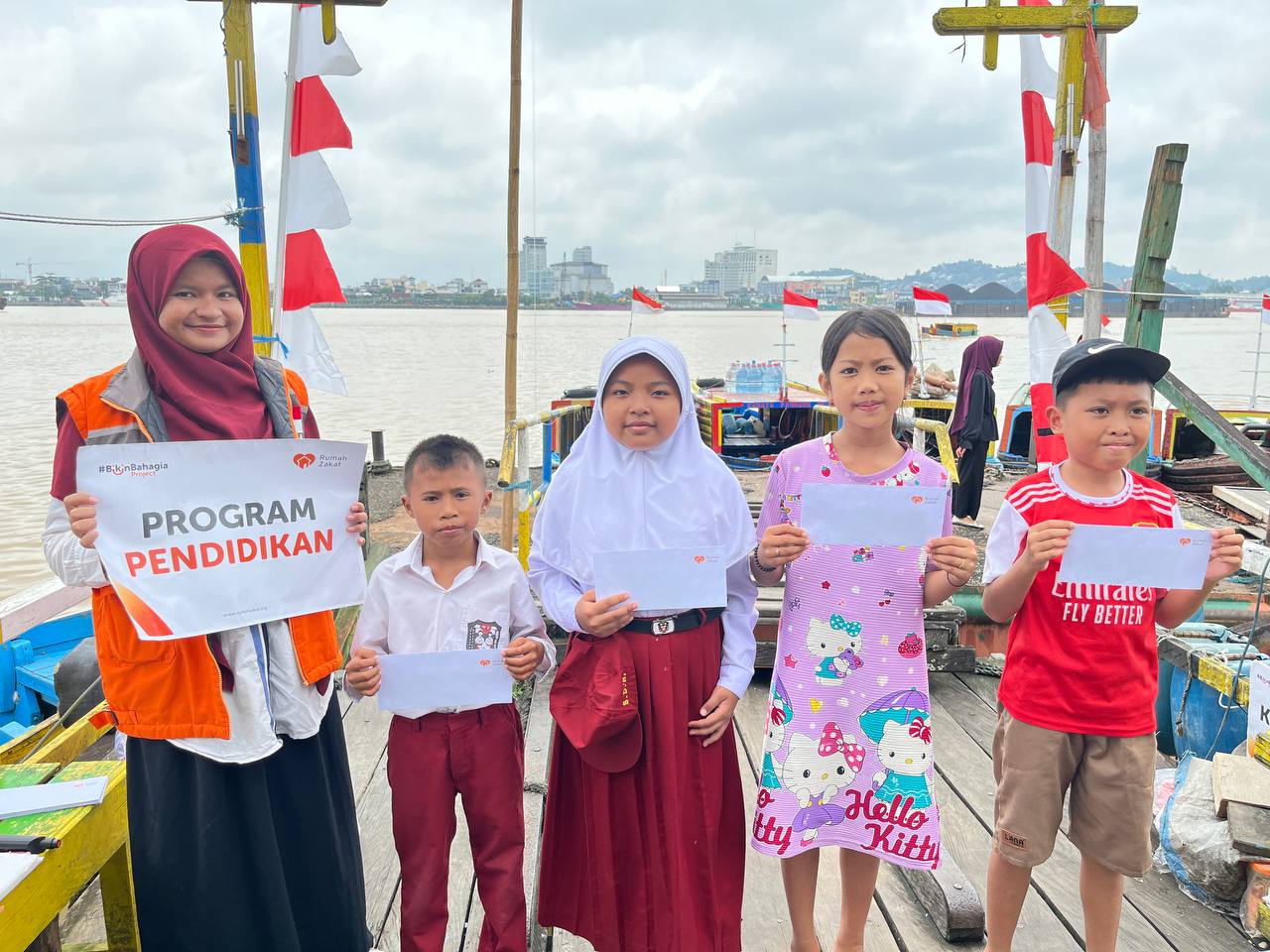 photo_2025-08-20_10-49-15 Rumah Zakat Samarinda bantuan pendidikan menyerahkan perlengkapan sekolah kepada anak-anak pengemudi kapal klotok di Sungai Mahakam.