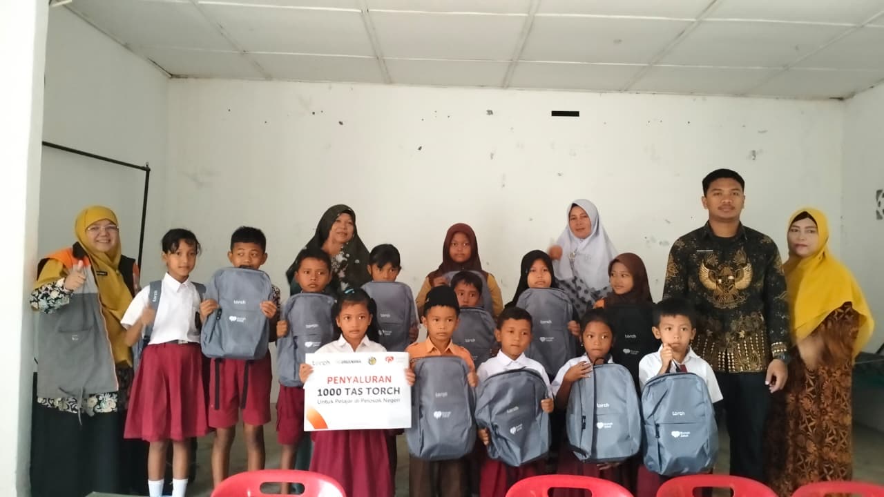 Torch 3 Pelajar Nagori Sahkuda Bayu menerima paket tas Torch dari Rumah Zakat.