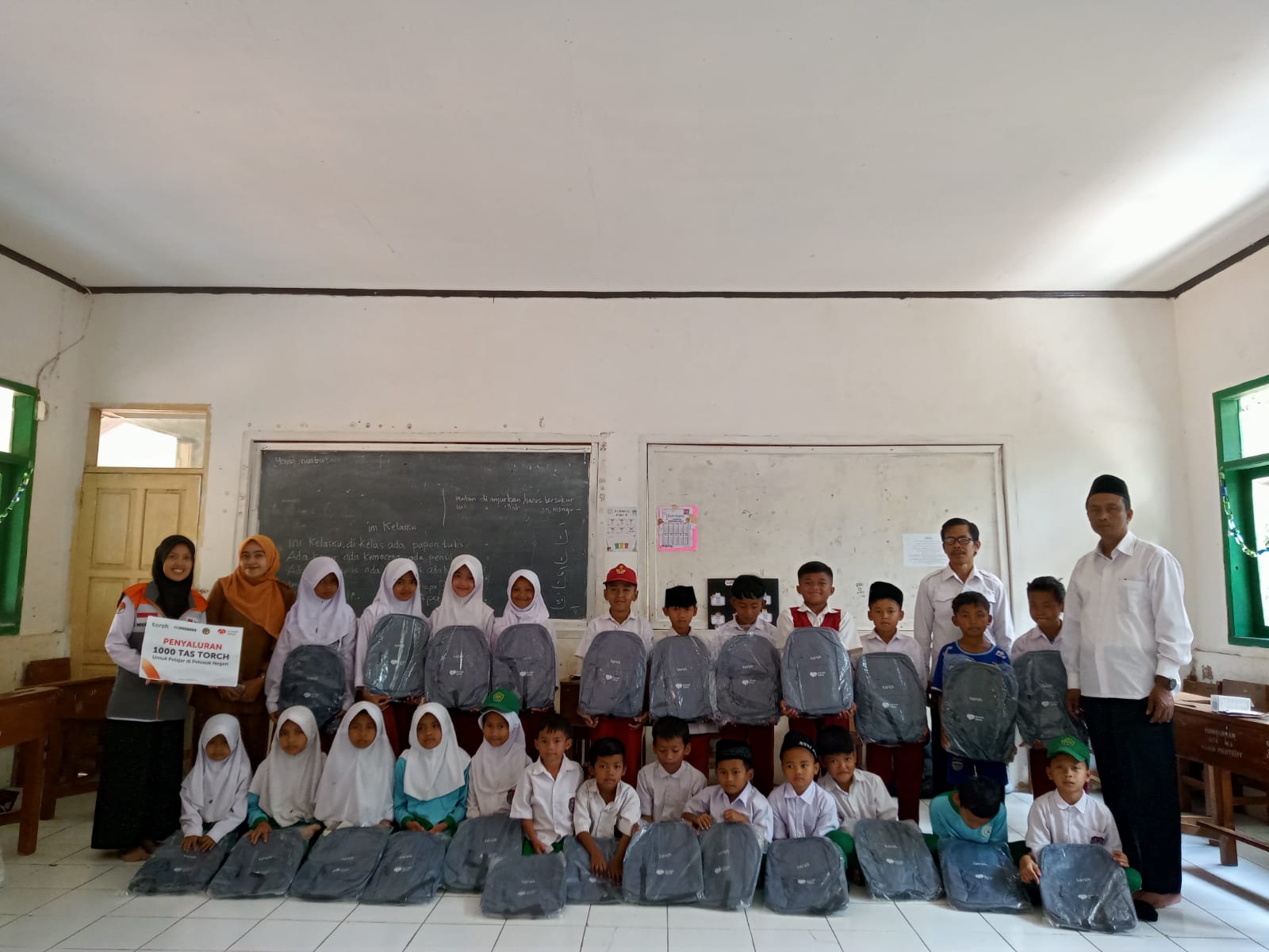 Torch 4 Relawan Rumah Zakat dan Torch bagikan tas sekolah baru kepada siswa Madrasah Ibtidaiyah Pasir Peuteuy di Pangandaran.