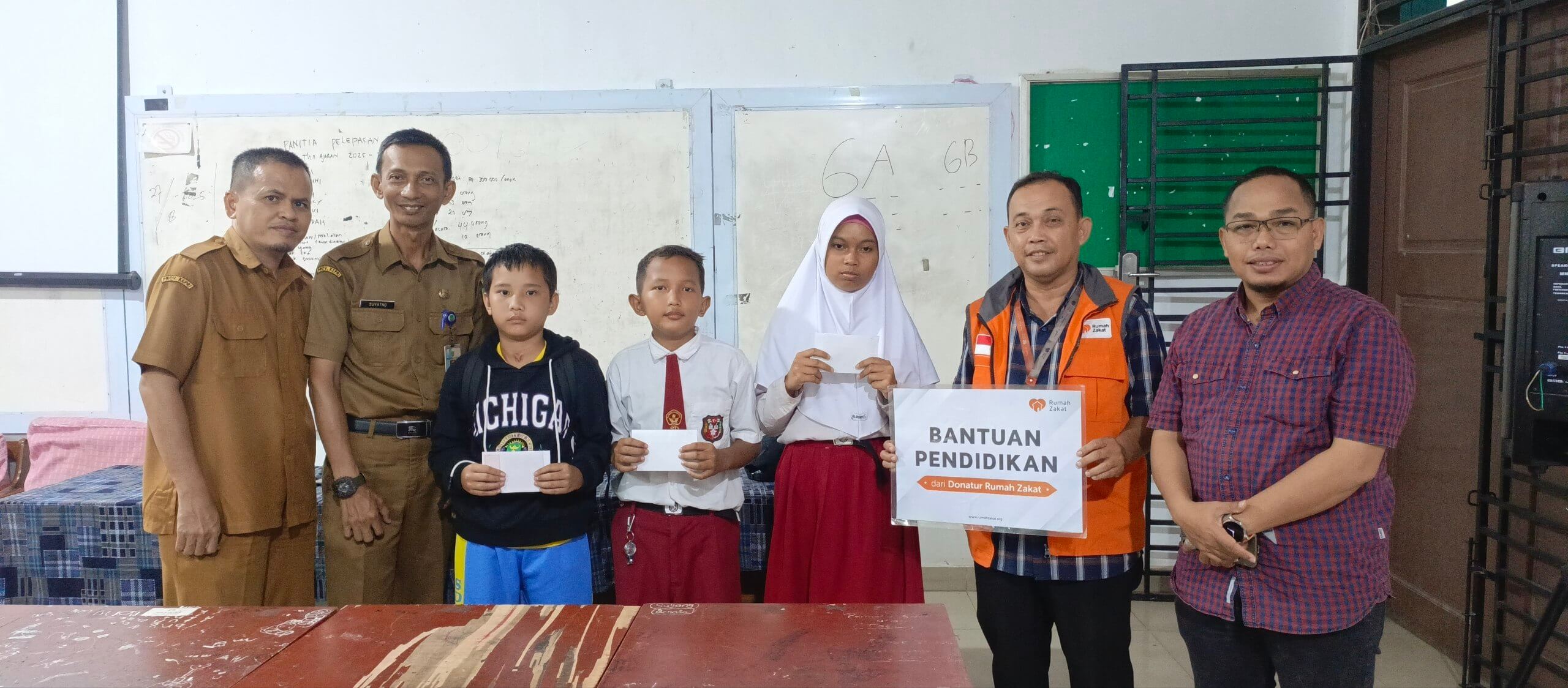 photo_2025-09-03_13-35-37 Relawan Rumah Zakat Batam menyerahkan bantuan pendidikan kepada anak yatim dhuafa di SDN 007 Batam.