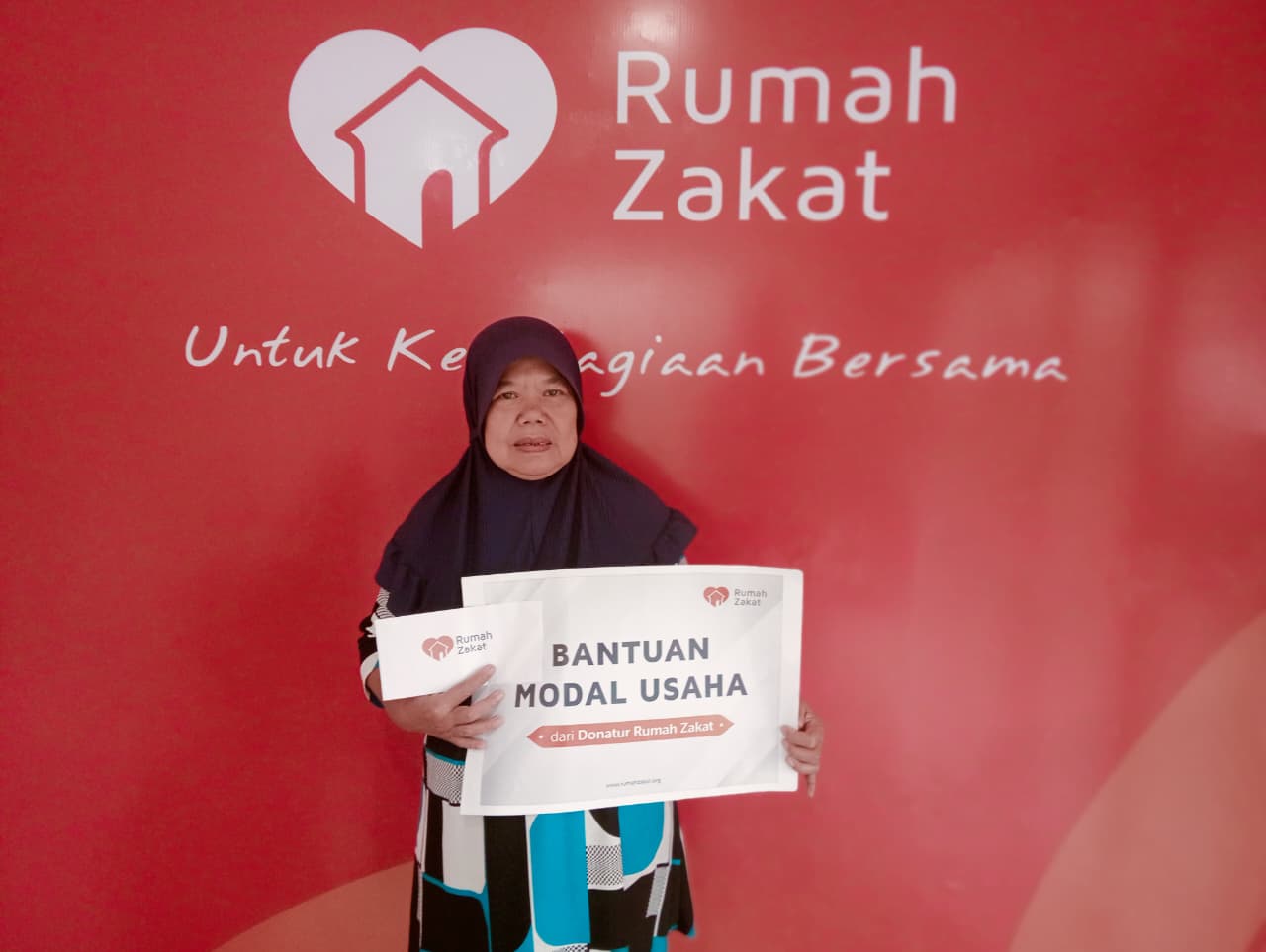 Petugas Rumah Zakat Cimahi menyerahkan bantuan modal usaha kepada Ibu Rohayati, penjual nasi kuning di Cimahi.