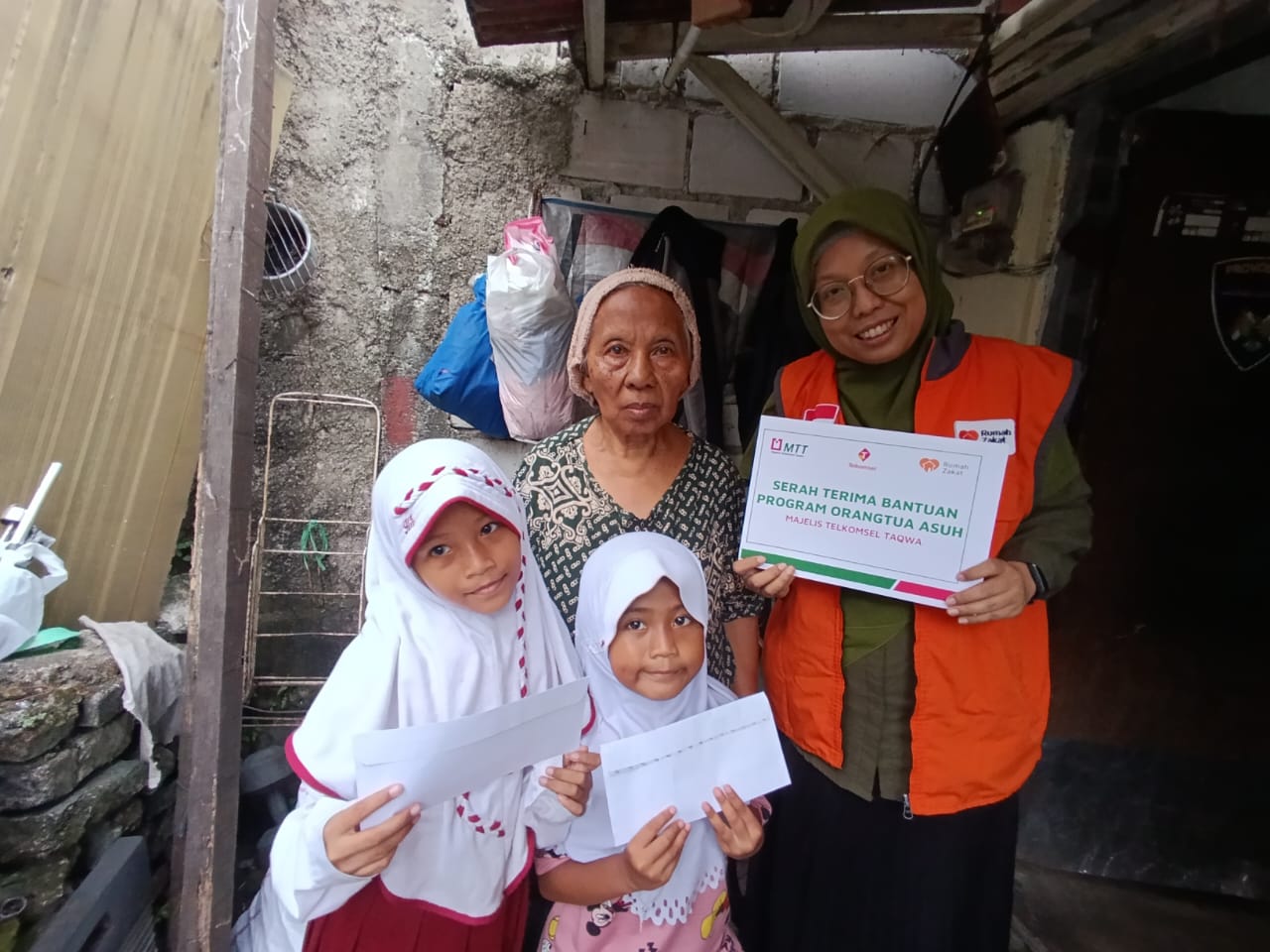 Relawan MTT dan Rumah Zakat menyerahkan bantuan pendidikan kepada dua cucu Nenek Yani di Bukit Duri melalui Gerakan Orang Tua Asuh Rumah Zakat.