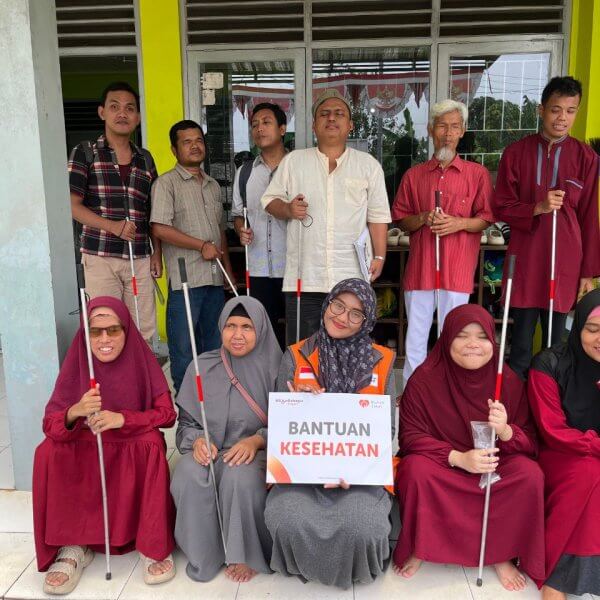 Petugas Rumah Zakat menyerahkan tongkat lipat kepada penyandang tunanetra di Majelis Taklim Makfufin, Tangerang Selatan, sebagai bentuk dukungan aksesibilitas bagi disabilitas netra.