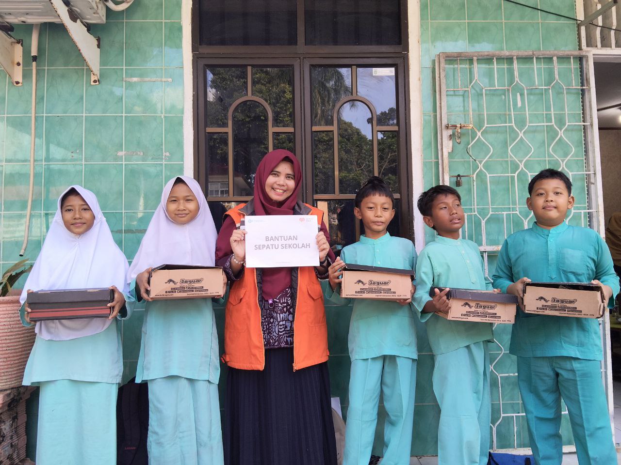 photo_2025-11-18_10-08-17 Anak-anak Batam menerima bantuan sepatu baru dari Rumah Zakat di sekolah mereka.