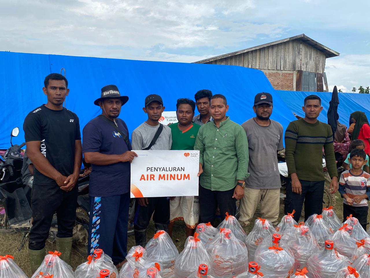 WhatsApp Image 2025-12-11 at 09.00.14 Relawan Rumah Zakat menyalurkan bantuan banjir Sumatra berupa galon air minum kepada pengungsi di Aceh Utara.